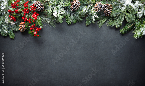 Foto Christmas and New Year background with fir branches and snowfall on dark stony b