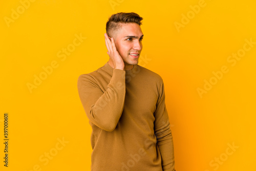 Young handsome caucasian man isolated trying to listening a gossip.