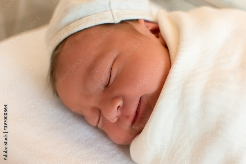 Portrait of cute and beautiful newborn baby in hospital after delivery. First days of life. Lifestyle Portrait of cute and beautiful newborn baby in hospital after delivery. First days of life. Lifestyle