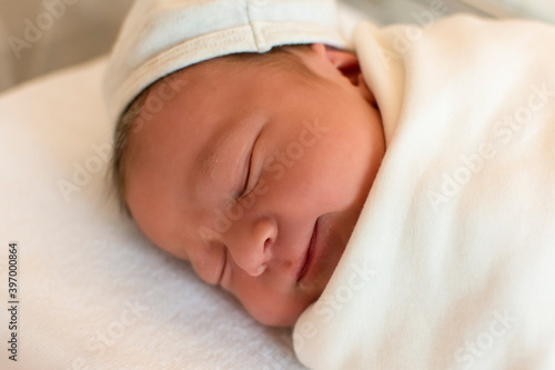 Portrait of cute and beautiful newborn baby in hospital after delivery. First days of life. Lifestyle