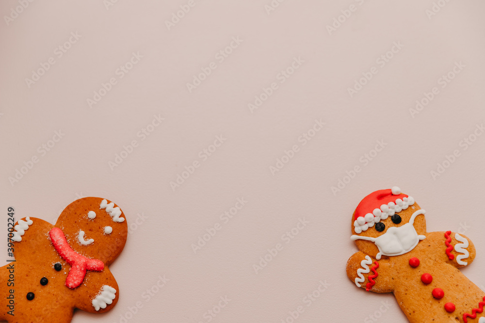 Obraz premium Two different gingerbread cookies: one with the image of a protective mask, and the other without it. The concept of conscious and safe celebration of Christmas and New Year