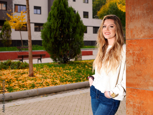 Young cheerful fitness woman walking in the city