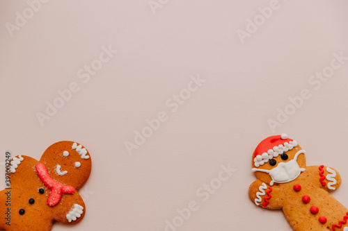 Two different gingerbread cookies: one with the image of a protective mask, and the other without it. The concept of conscious and safe celebration of Christmas and New Year