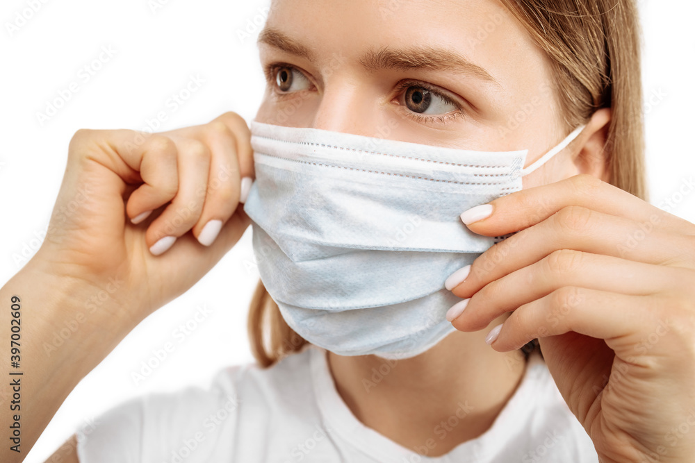 Young woman using medical protective mask to protect health and prevent virus, epidemic and infectious diseases, on white background Young woman using medical protective mask to protect health and prevent virus, epidemic and infectious diseases, on white background
