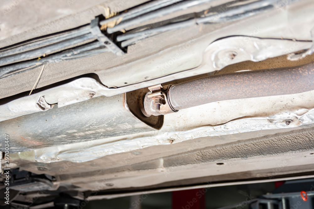 Rusty and old exhaust pipe under the car, bottom view. Rusty and old exhaust pipe under the car, bottom view.