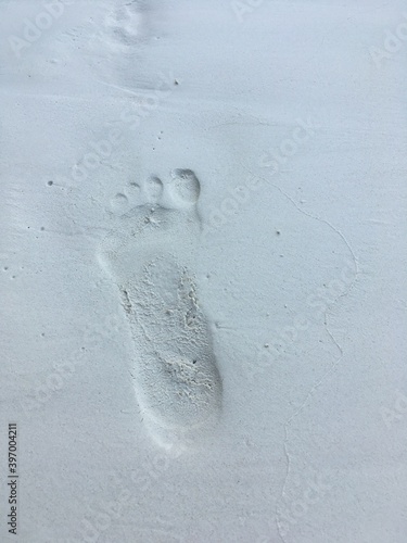 man's footprint on a white sand