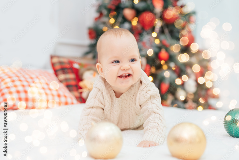 Little child under Christmas tree. baby boy with gifts under Christmas tree with many gift boxes presents. Happy Holidays, New year. Cozy warm winter evening at home. Xmas time Little child under Christmas tree. baby boy with gifts under Christmas tree with many gift boxes presents. Happy Holidays, New year. Cozy warm winter evening at home. Xmas time