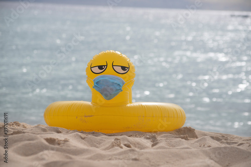  YELLOW INFLATABLE LIFEGUARD DUCK WITH MOUTH COVER ON THE SHORE OF THE BEACH ON A SUNNY DAY