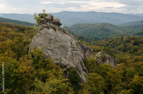 Rocks towering over colorful autumn beech forest