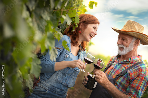 Happy couple winemaker with wineglass in the vineyard