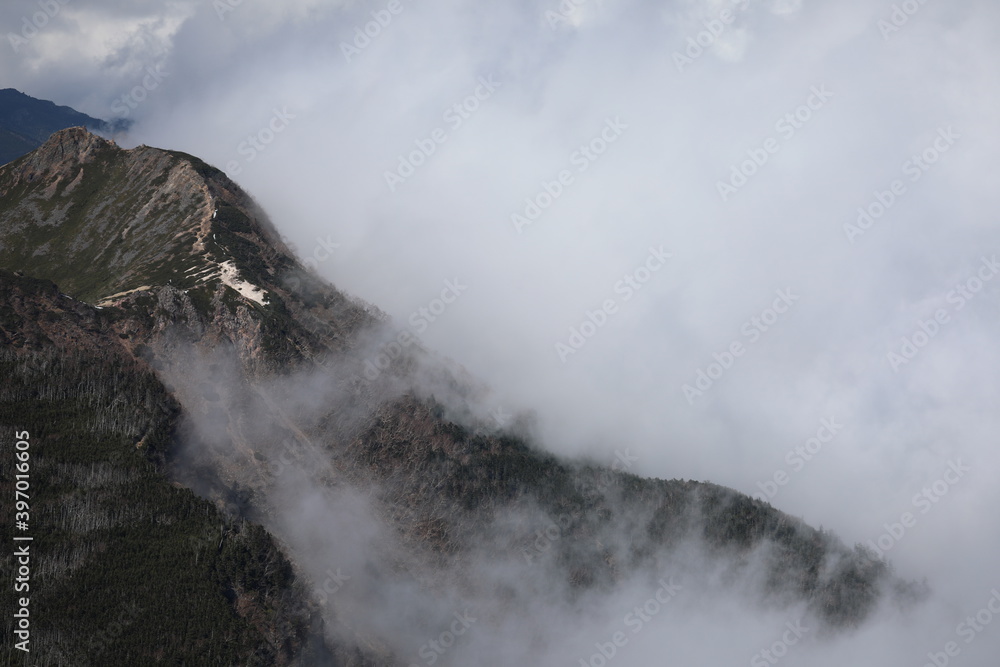 Mountain ridge covered with deep cloud
