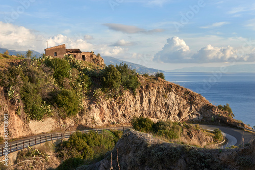suggestive view of the coast of Eastern Sicily  on the road leading to Forza d Agr   at the first light of the new day and rural house