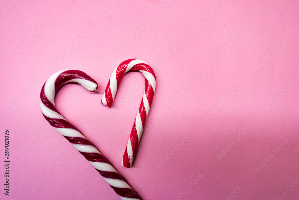 Heart shaped candy canes on pink background Heart shaped candy canes on pink background
