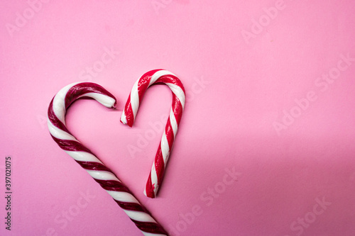Heart shaped candy canes on pink background