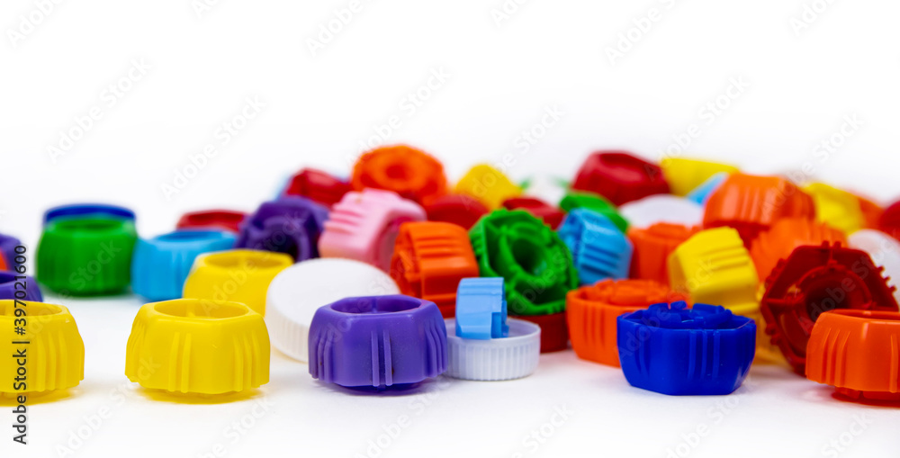 Multi-colored plastic bottle caps on a white background. Ecology and recycling concept. Multi-colored plastic bottle caps on a white background. Ecology and recycling concept.