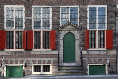 Canvas Print Old House with Red Shutters and Green Door in Amsterdam