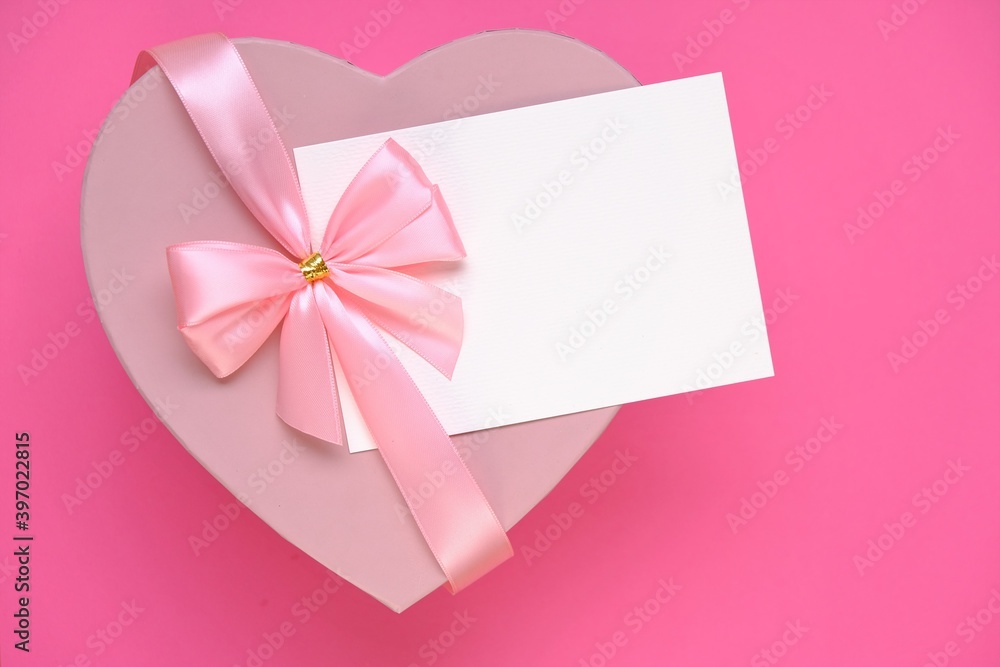Valentine's day holiday.Pink heart box with bow ,with white card On a light pale pink background. Gift heart.Blank postcard.Love and passion.Valentine's Day gift.copy space.Mother's day Valentine's day holiday.Pink heart box with bow ,with white card On a light pale pink background. Gift heart.Blank postcard.Love and passion.Valentine's Day gift.copy space.Mother's day