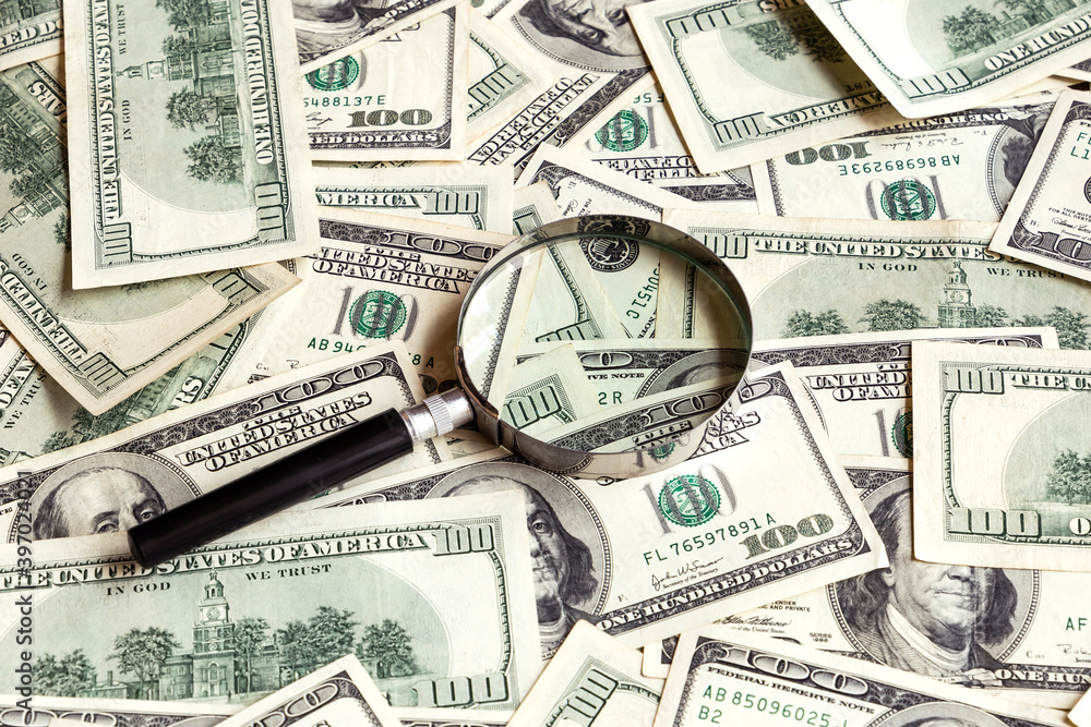 Magnifier on dollar banknotes background. 100 USA dollar bills with lens. Financial analysis. Investments. Cash and savings. American money. Business, finance concept. Copy space. Magnifier on dollar banknotes background. 100 USA dollar bills with lens. Financial analysis. Investments. Cash and savings. American money. Business, finance concept. Copy space.