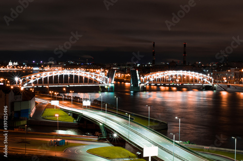 large drawbridge Bolsheokhtinsky beautiful bridge across the Neva river, night city of St. Petersburg. Fog in the night city sky. Amazing reflection on the river. bird's eye view of the road and city