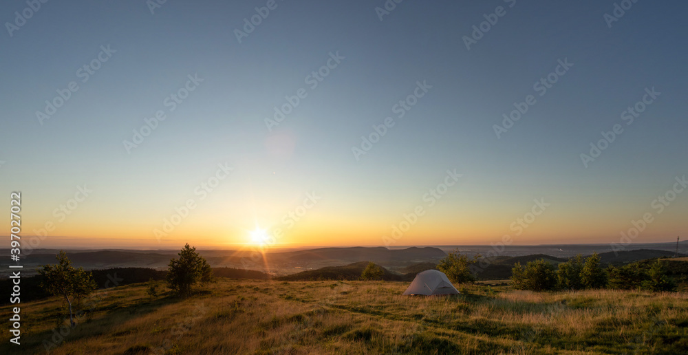 Tent at sunrise on the top of the mountain