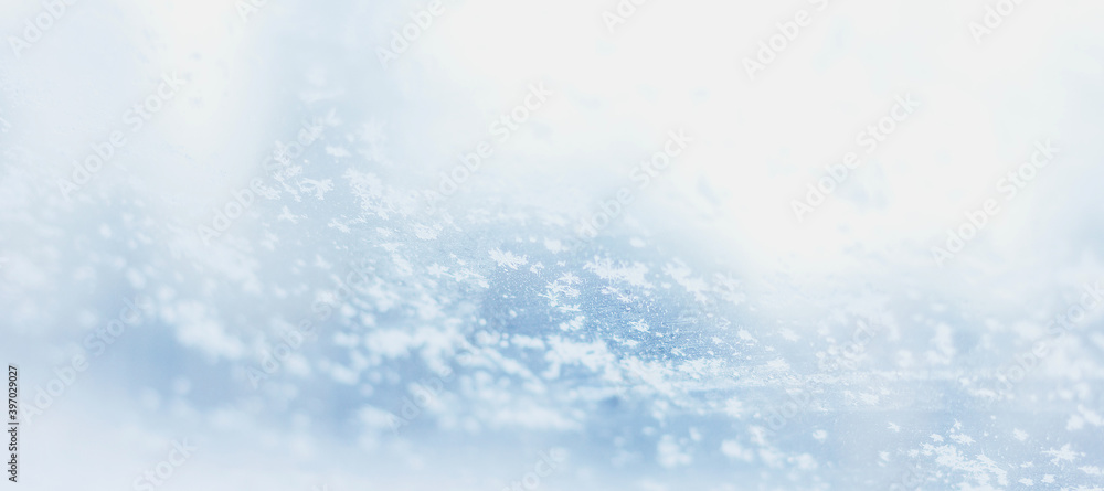 Hoarfrost snowflakes on frozen glass in winter background selective focus. Winter is here backdrop banner Hoarfrost snowflakes on frozen glass in winter background selective focus. Winter is here backdrop banner