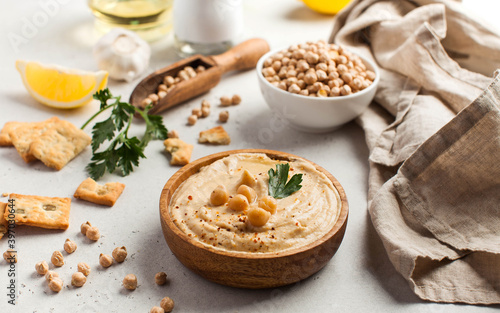 Hummus in a wooden plate with parsley and croutons. Dishes of chickpeas, a vegetarian dish.