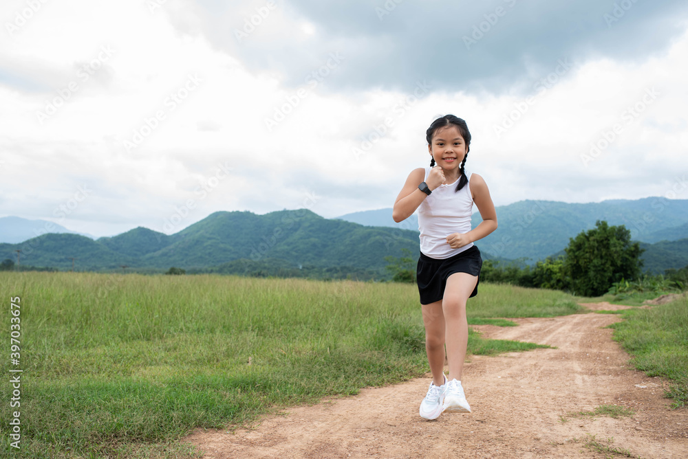 Happy Funny little asian girl fitness woman running at morning tropical forest trail. Athletic young child running in the nature. Healthy lifestyle. Happy Funny little asian girl fitness woman running at morning tropical forest trail. Athletic young child running in the nature. Healthy lifestyle.