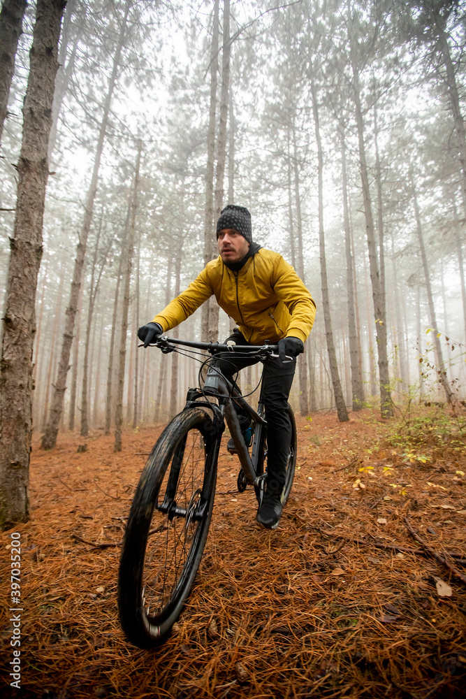 Young man biking through autumn forest Young man biking through autumn forest