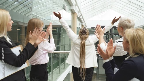 Business lady is happy to win in project, colleagues celebrate, congratulate, clapping hands, in the hall.