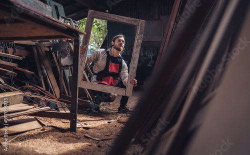 Carpenter man cutting wood with saw. craftsman working workshop factory industry.  Capenter worker with mask protection. photo