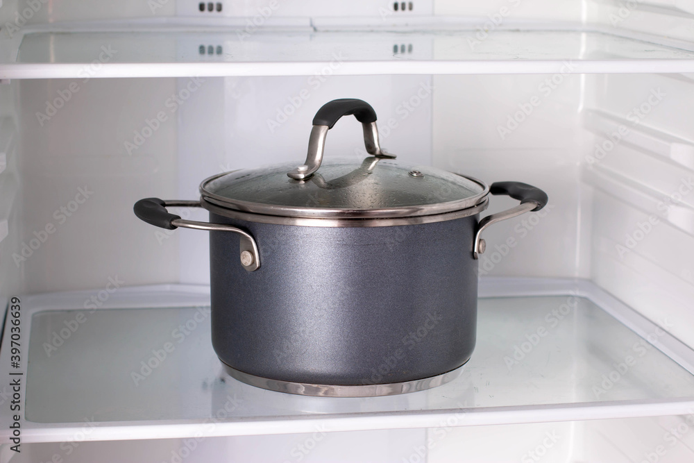 Open refrigerator with food in kitchen. Pot in the refrigerator Open refrigerator with food in kitchen. Pot in the refrigerator