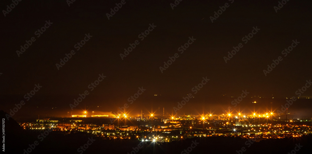 Panorama of a small night city taken from the mountain