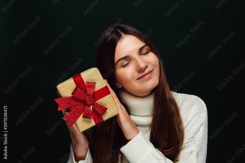 Young woman with long hair holds christmas gift Young woman with long hair holds christmas gift