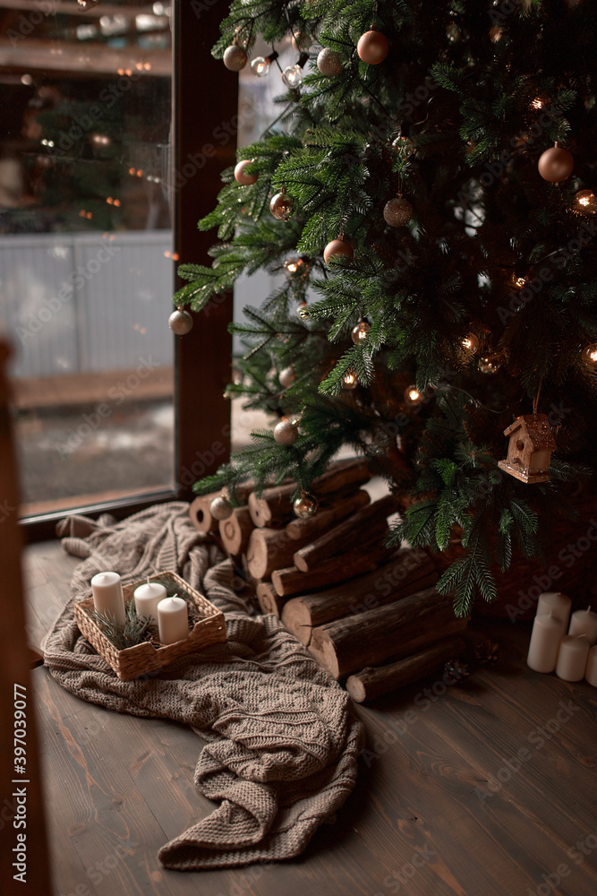 Christmas tree with presents and lights reflecting in windows around the tree in modern home