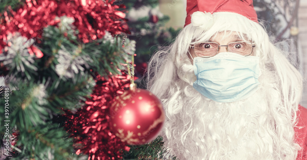 funny Santa Claus wearing face mask and eyeglasses looking ahead staying near Christmas tree
