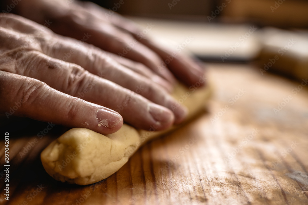 Senior woman is rolling pastry dough by hand Senior woman is rolling pastry dough by hand