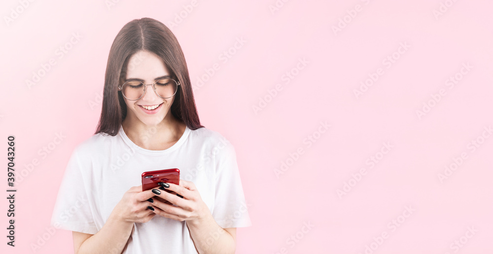 Image of happy american woman smiling and using cellphone isolated over pink wall with copyspace Image of happy american woman smiling and using cellphone isolated over pink wall with copyspace