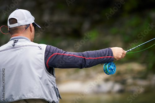 Fisherman in special uniform fishing in mountain river