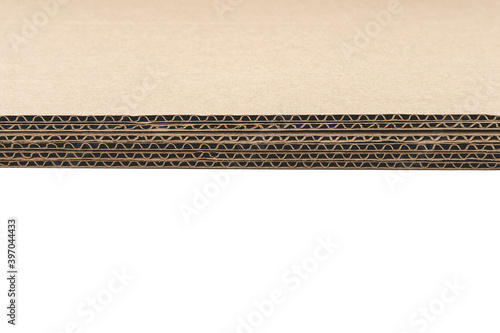 Five sheets of cardboard are laid tightly and evenly on top of each other. Thick dark paper isolated on a clean white background. The subject casts a hard, narrow shadow along the entire edge.