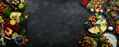 Big set of vegetables, fruits, berries and food on a black stone background. Free space for text. Top view.