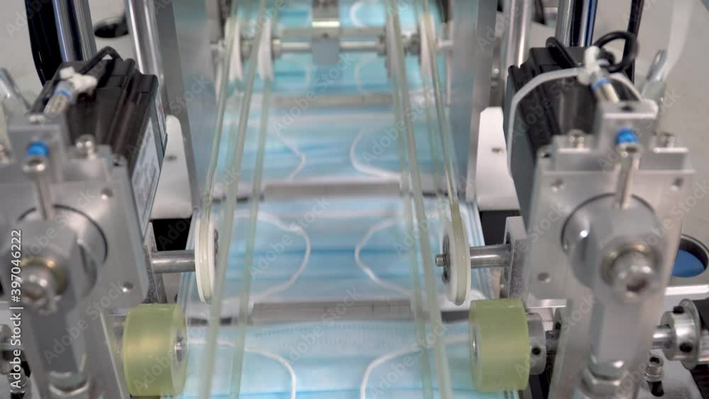 The process of manufacturing line production medical face mask with automatic machinery in an industrial factory . Shortages during the coronavirus pandemic or covid-19 outbreak The process of manufacturing line production medical face mask with automatic machinery in an industrial factory . Shortages during the coronavirus pandemic or covid-19 outbreak