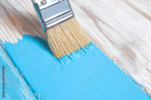 brush paints blue paint white old boards close up