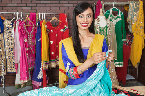 Portrait of an Indian female dressmaker working at design studio photo