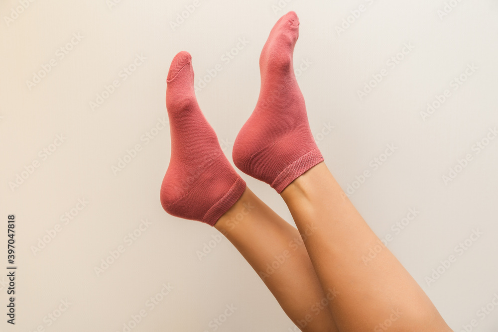 beautiful woman legs in new pink socks on a light beige background beautiful woman legs in new pink socks on a light beige background