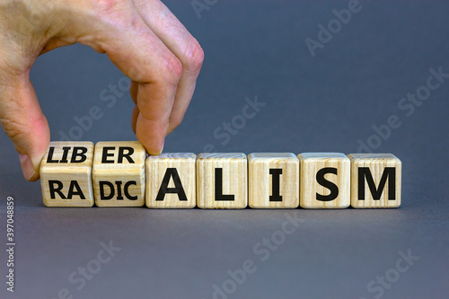 Radicalism or liberalism symbol. Male hand turns cubes and changes the word 'radicalism' to 'liberalism'. Beautiful grey background. Business and radicalism or liberalism concept. Copy space. photo