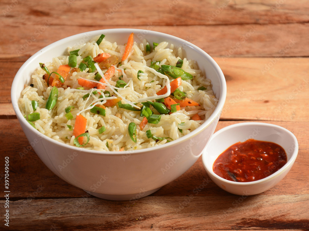 Healthy and tasty veg fried rice made of mixed veggies served in bowl over a rustic wooden background, Indo chinese, Indian cuisine, selective focus Healthy and tasty veg fried rice made of mixed veggies served in bowl over a rustic wooden background, Indo chinese, Indian cuisine, selective focus