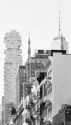 Black and white photo of modern and old buildings with fire escapes, New York City, USA.
