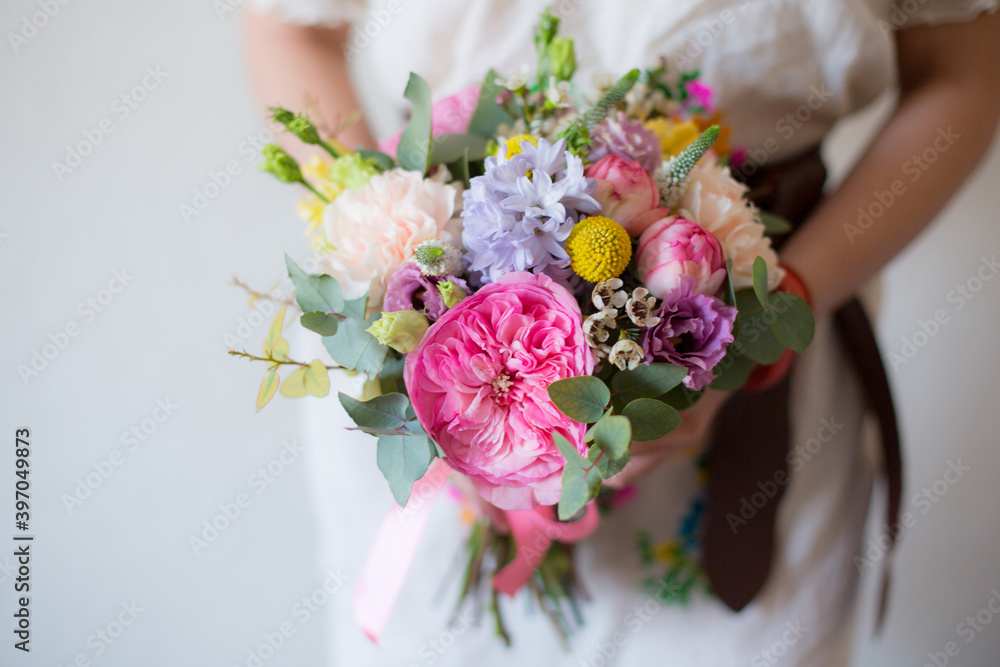 Fototapeta premium Amazing spring flower bouquet with garden roses, Veronica, craspedia, waxflower, carnations and eucalyptus