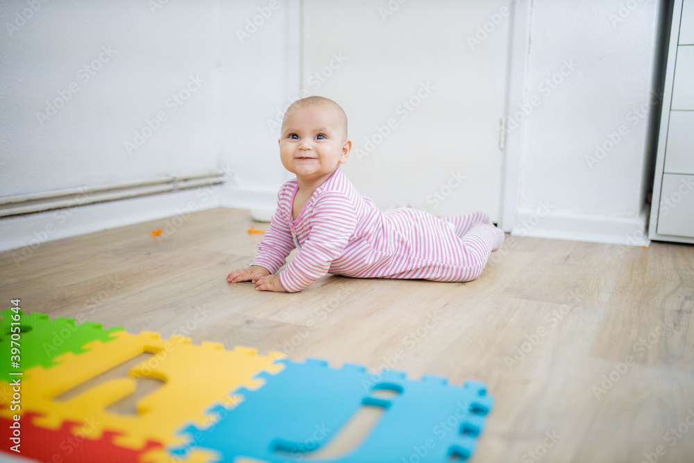 Adorable baby lying face down on the wooden floor Adorable baby lying face down on the wooden floor