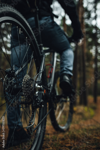 Close view on rear wheel of a mountain bike, bicycle's gear set, active life in forest